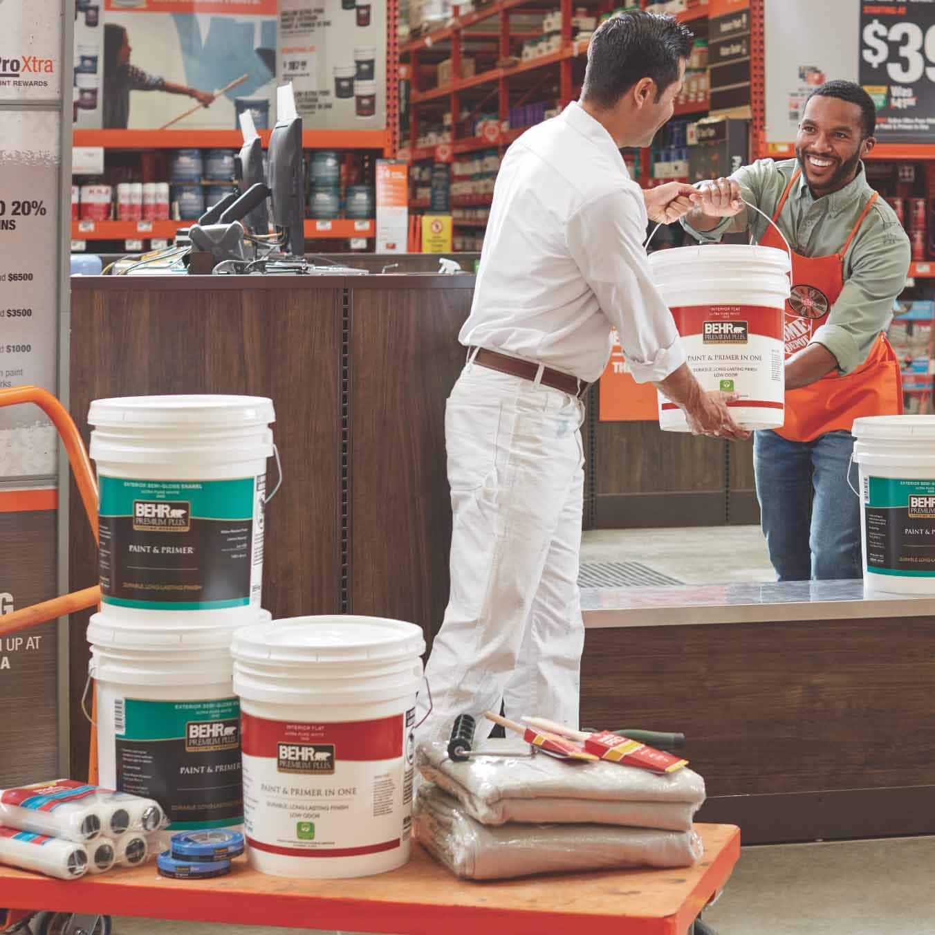 A Home Depot associate hands paint to a shopping Pro.