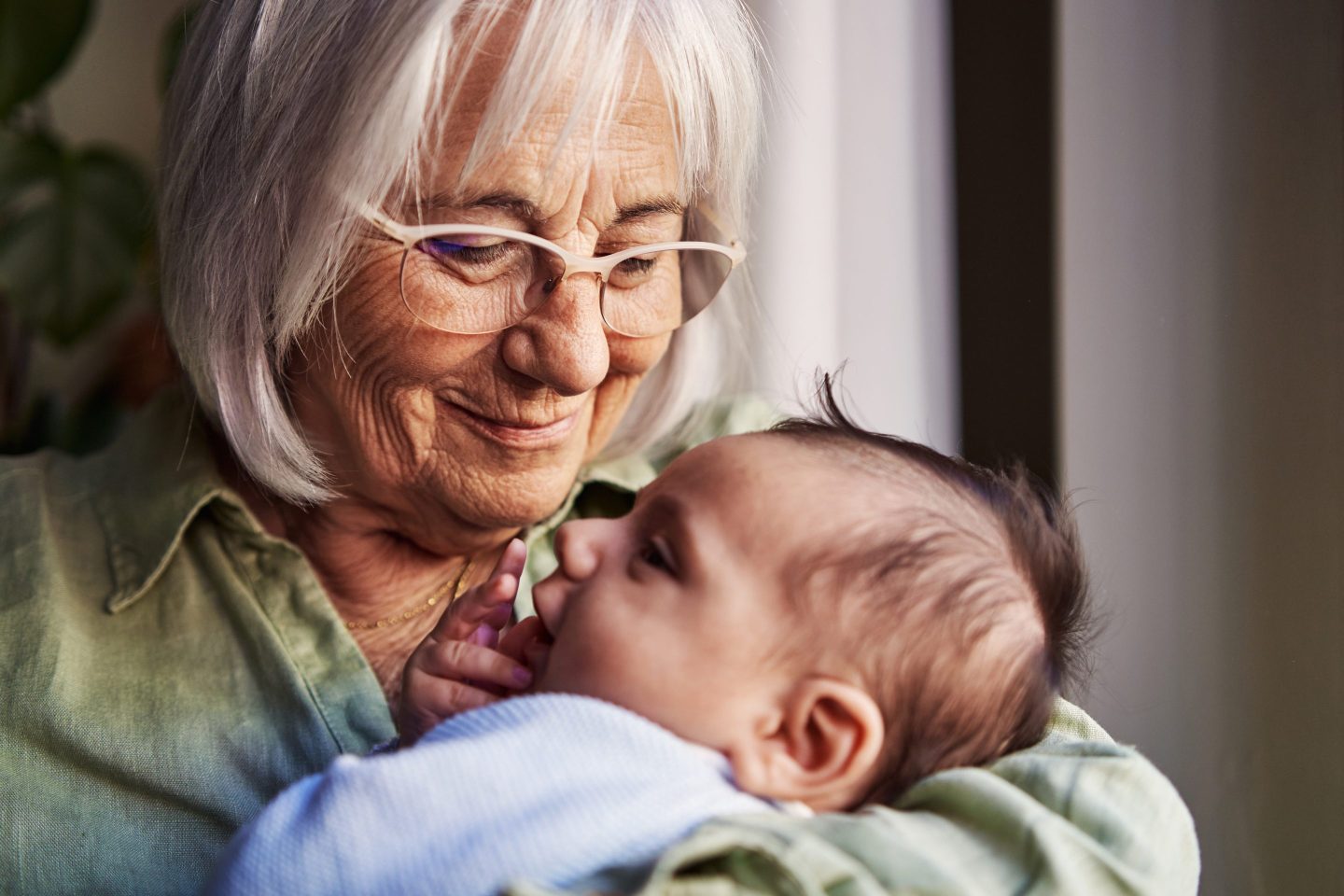 Senior woman holding her infant grandchild
