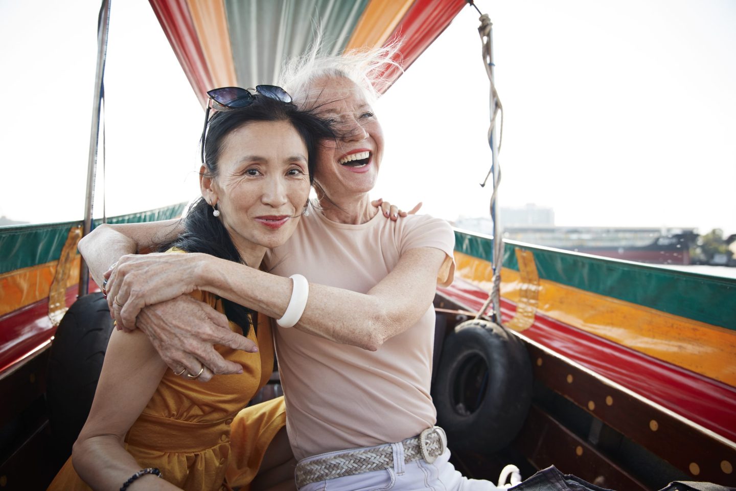 Portrait of woman with arm around sitting with friend in boat