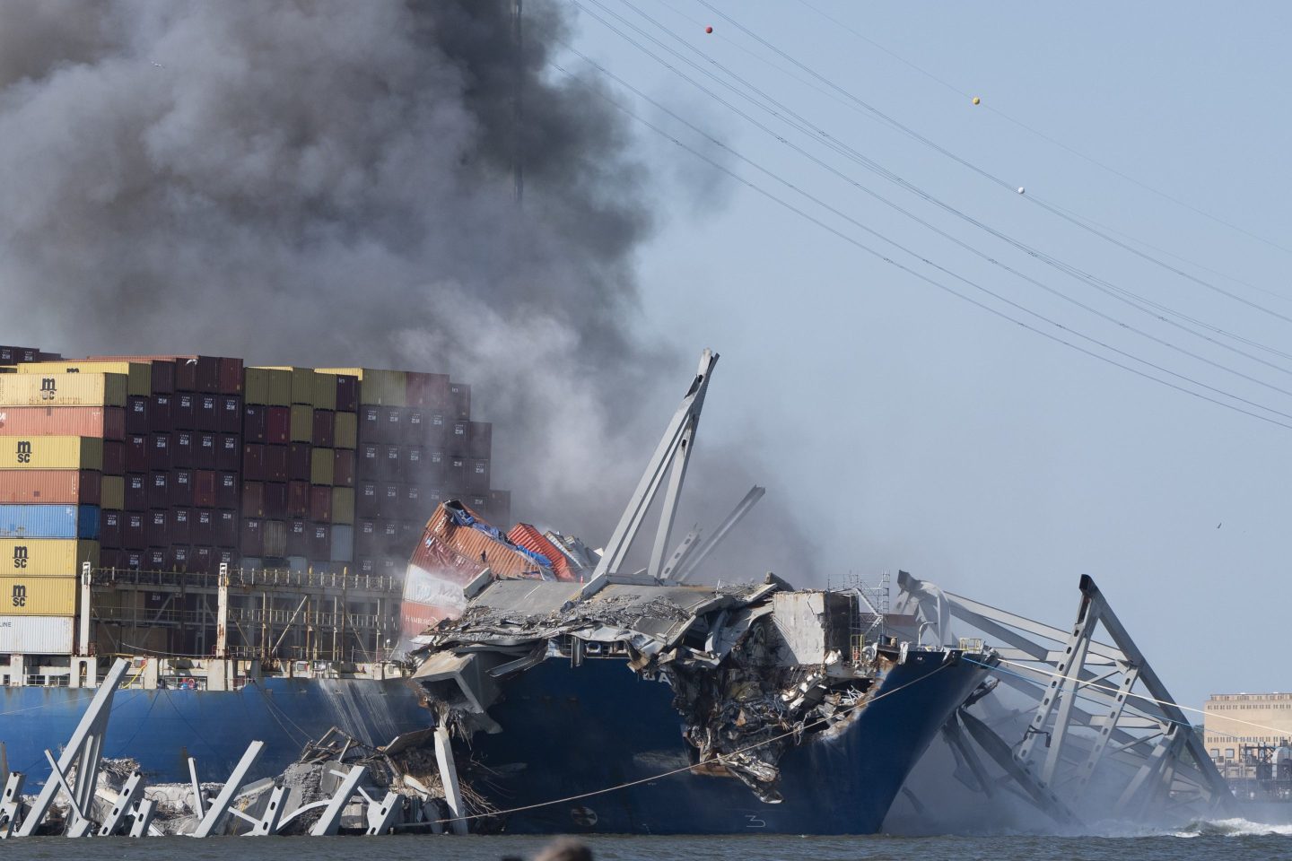 Explosive charges are detonated to bring down sections of the collapsed Francis Scott Key Bridge resting on the container ship Dali on Monday, May 13, 2024, in Baltimore. (AP Photo/Mark Schiefelbein)