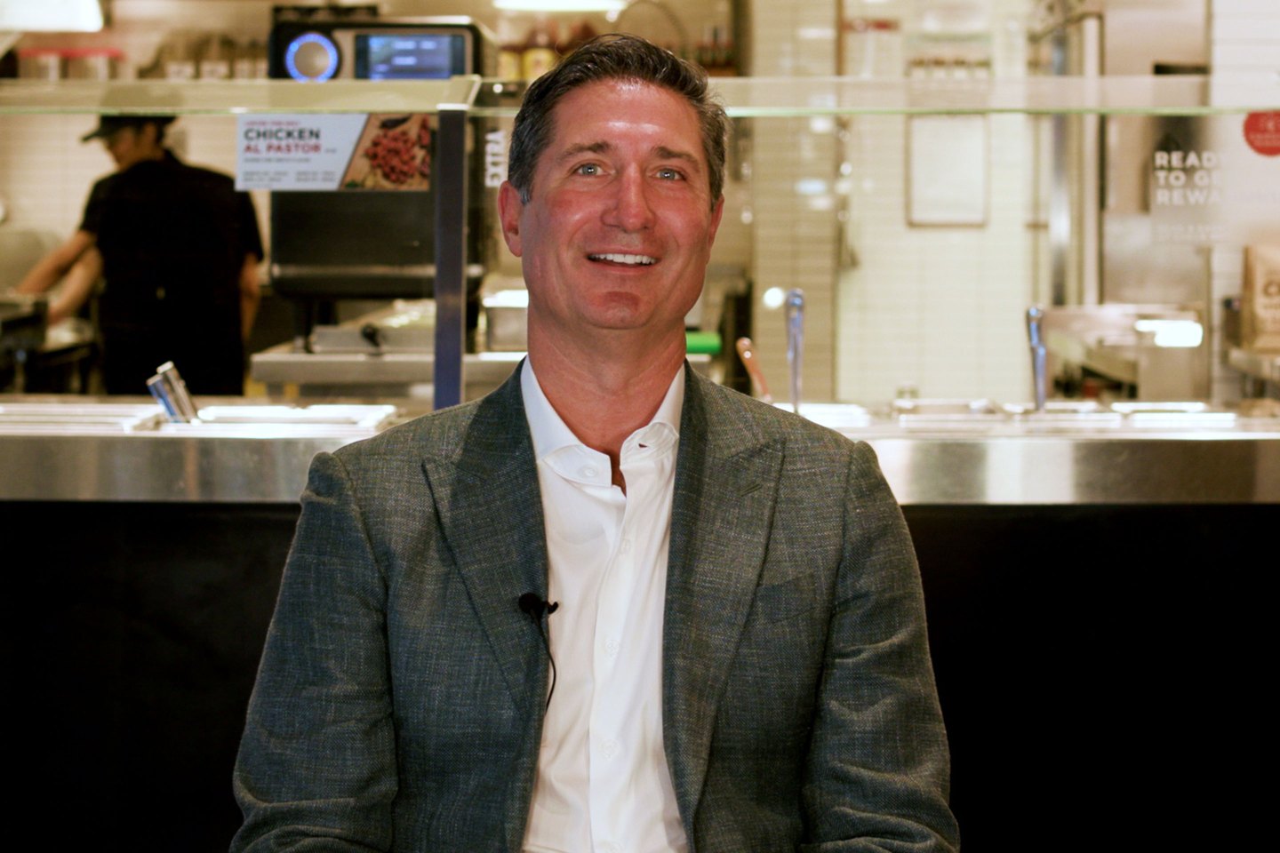 Chipotle CEO sitting in front of a Chipotle counter
