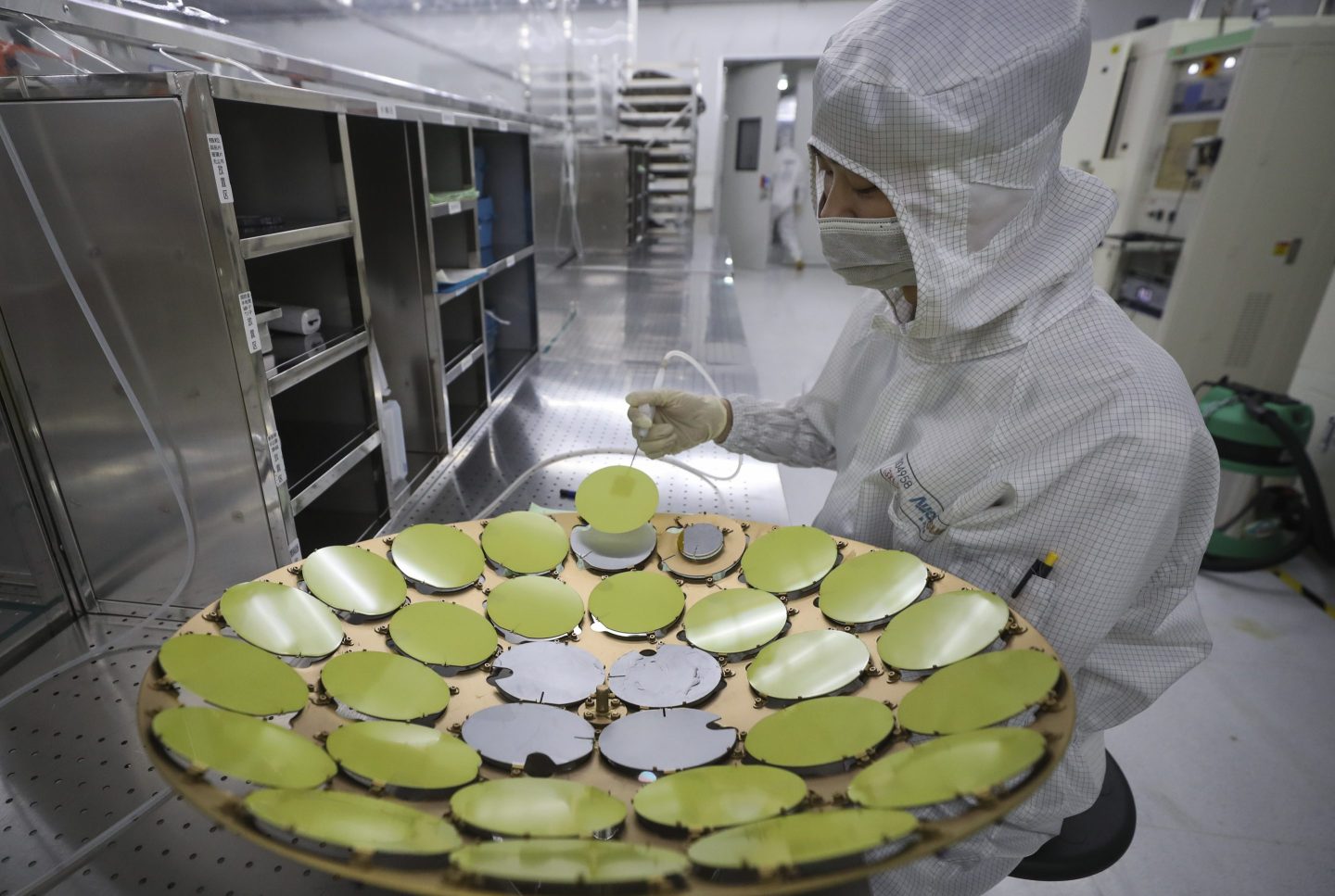 Workers process chips at a workshop of an optoelectronic technology company in Huai'an, China, on May 11, 2024.