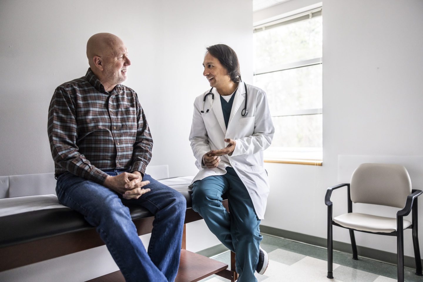 Doctor discussing treatment with senior man in exam room