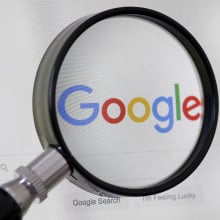 Google logo behind magnifying glass