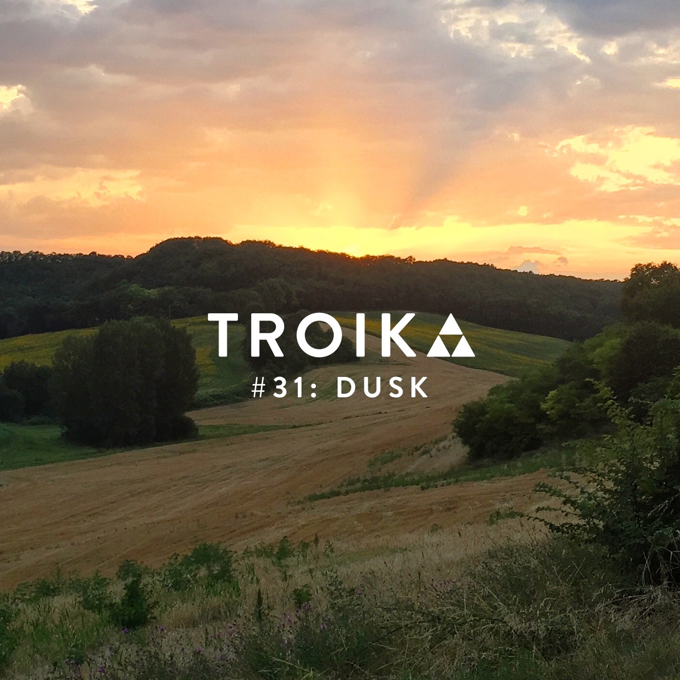 Troika #31: Dusk A French field at dusk, with the last rays of sunlight beaming out from the centre of the horizon