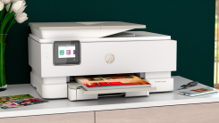 An HP Envy Inspire printer surrounded by printed photos.