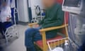 Video grab showing person sitting on chair in corridor