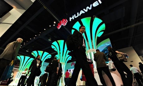 People walk past the Huawei booth