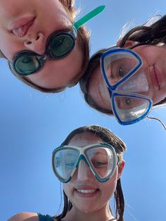 three girls wearing goggles and snorkels are standing in front of the camera