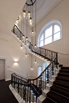 an elegant staircase with chandelier and glass balls