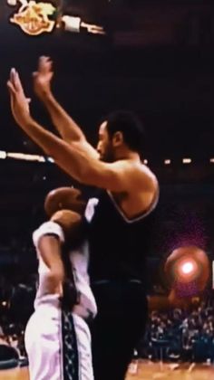 the basketball player is trying to block the ball from being blocked out by another player