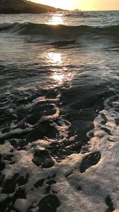 the sun is setting over the ocean waves