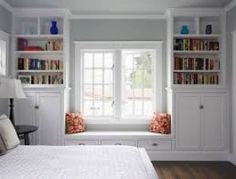 a bedroom with built in bookshelves and a bed