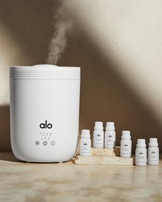the aroma diffuser is next to eight bottles of essential oils on a countertop