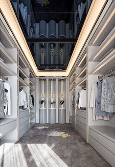 an empty walk in closet with clothes hanging on the walls and open shelving units