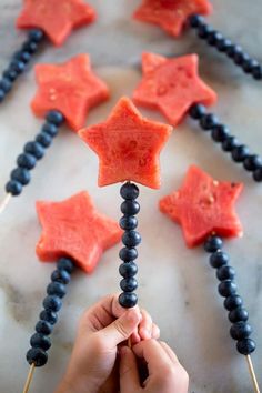someone is making star shaped popsicles out of watermelon and black beads on a stick
