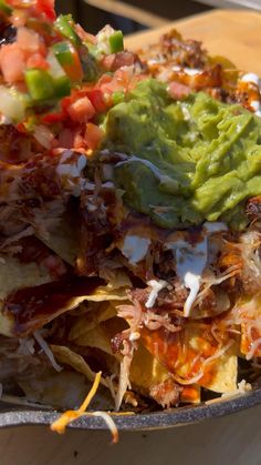 a bowl filled with nachos and guacamole on top of it