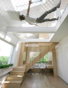 a man is falling down the stairs in a house that has been decorated with white tiles and wood