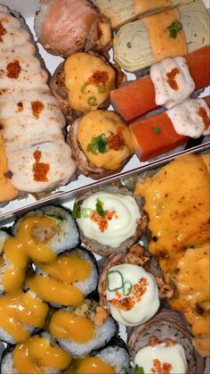 several different types of sushi on display in trays with sauce and toppings