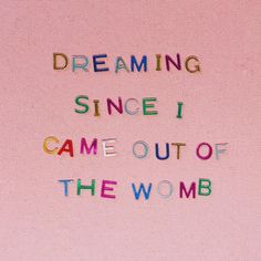 the words dreaming since i came out of the womb are written in multicolored letters