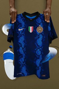 a man holding up a blue shirt with the italy national team on it's chest
