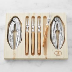 a set of knives and spoons in a wooden tray