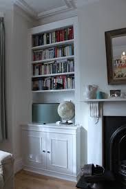 a living room filled with furniture and a fire place next to a bookshelf