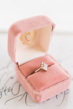 an engagement ring in a pink velvet box