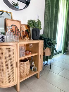 a wooden cabinet with wicker baskets and wine glasses sitting on it's side