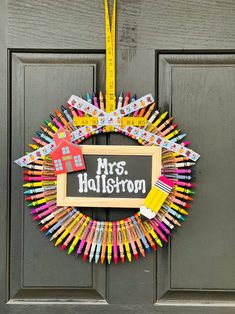 a wreath made out of crayons with a chalkboard on it