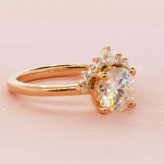 a gold ring with an oval cut diamond in the center and two smaller round diamonds on each side