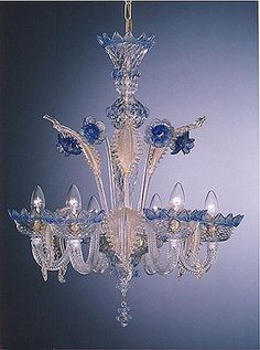 a crystal chandelier with blue glass flowers hanging from it's centerpiece