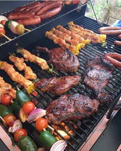 the grill is full of meat and vegetables