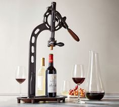 a wine glass holder with two glasses and a bottle next to it on a table