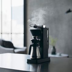 a coffee maker with steam coming out of it
