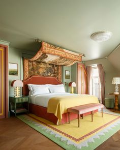 a bedroom with a large bed and paintings on the wall