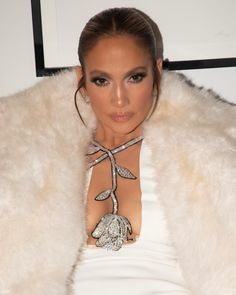 a woman in a white dress and fur coat