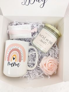 a gift box containing a coffee mug, candle and marshmallows