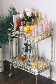 a gold bar cart filled with drinks and liquor
