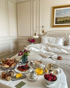 a bed room with a neatly made bed and trays of food