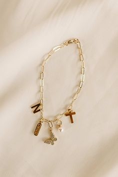 a gold bracelet with charms and crosses on it