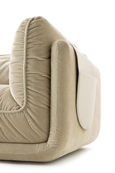 an upholstered chair with white cushions on it
