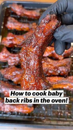 a person in black gloves holding up a piece of meat on a grill with the words how to cook baby back ribs in the oven