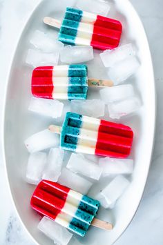 red, white and blue popsicles on a plate with toothpicks in them