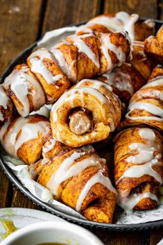 a pan filled with cinnamon rolls covered in icing