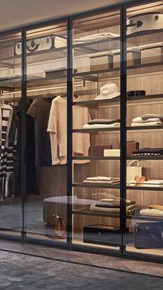 an empty clothing store with glass walls and shelves filled with clothes, hats, and other items