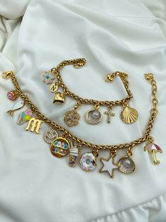 a gold bracelet with charms and other items on it