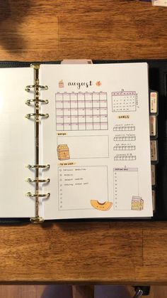 an open planner sitting on top of a wooden table