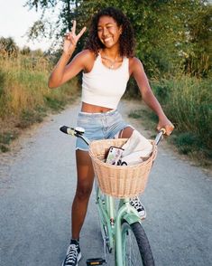 a woman riding a bike with a basket and peace sign on the front, while standing next to her