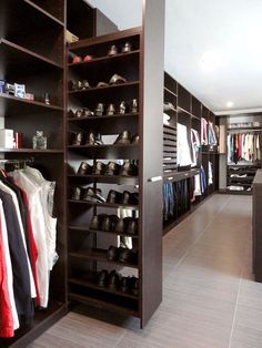 a walk in closet filled with lots of shoes and clothes on shelves next to each other